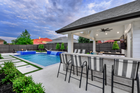 Black and white striped chairs near an outdoor kitchen