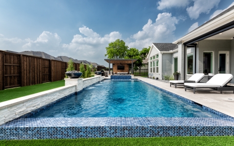 Ground view of blue tile and pool with an outdoor sitting area
