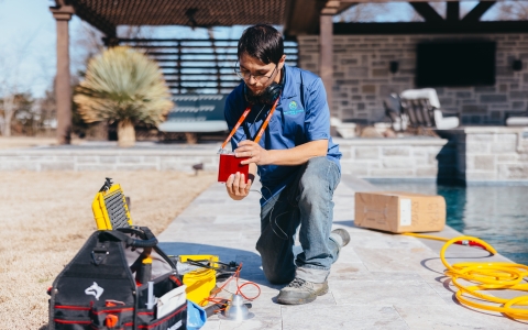 man kneeling by poolside for leak detection