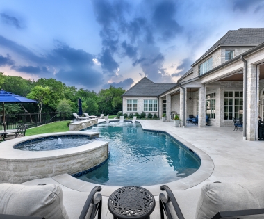 Fountain, chairs, and a pool on an evening