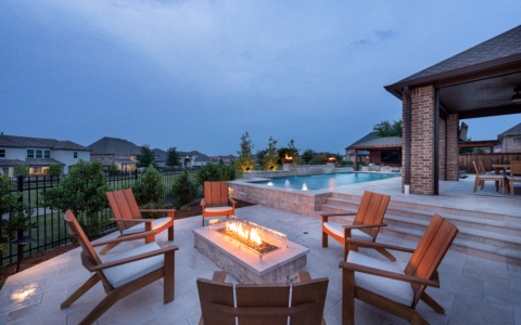 Nighttime view of a firepit with wooden chairs