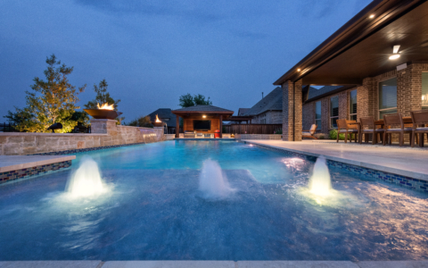 Nighttime view of a pool with fountains