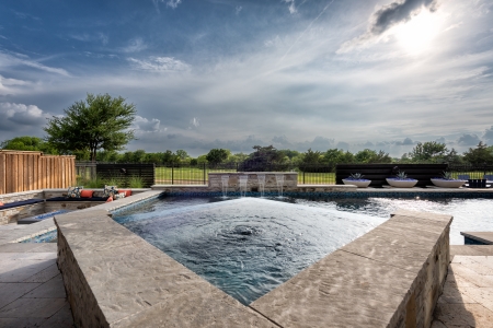 Spa above a pool on a cloudy day