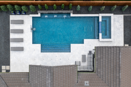 Bird's eye-view of geometric pool with integrated spa and pool fountains