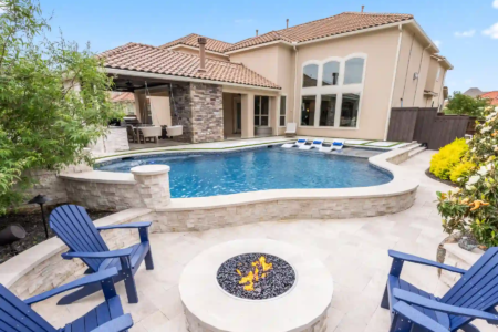 Chairs and a firepit near a raised pool