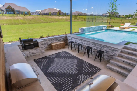 Outdoor kitchen with a grill and stools