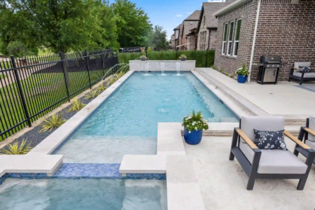 Close up view of a pool, hot tub, and chairs